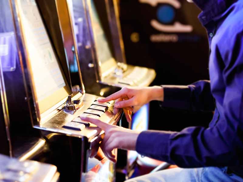 Man using an electronic slot machine